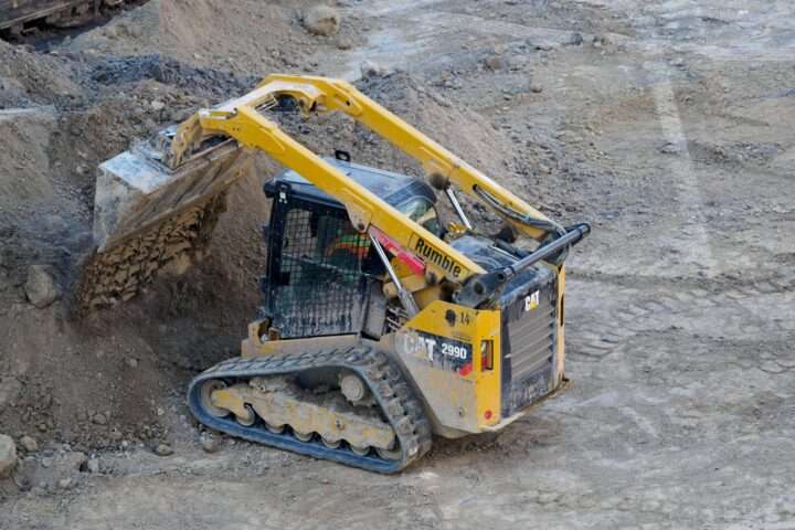 A small construction vehicle moving dirt.