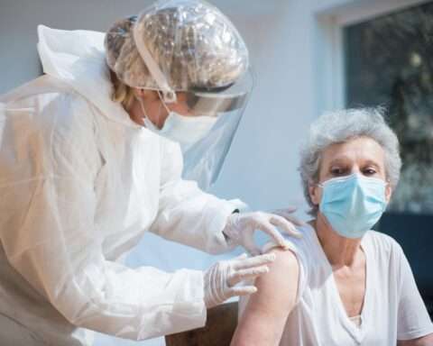 A caregiver and a senior in a medical facility.