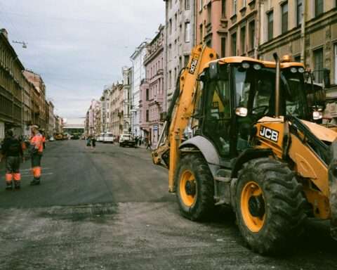 Construction vehicles and a crew on an urban street.