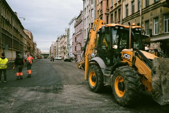 Construction vehicles and a crew on an urban street.