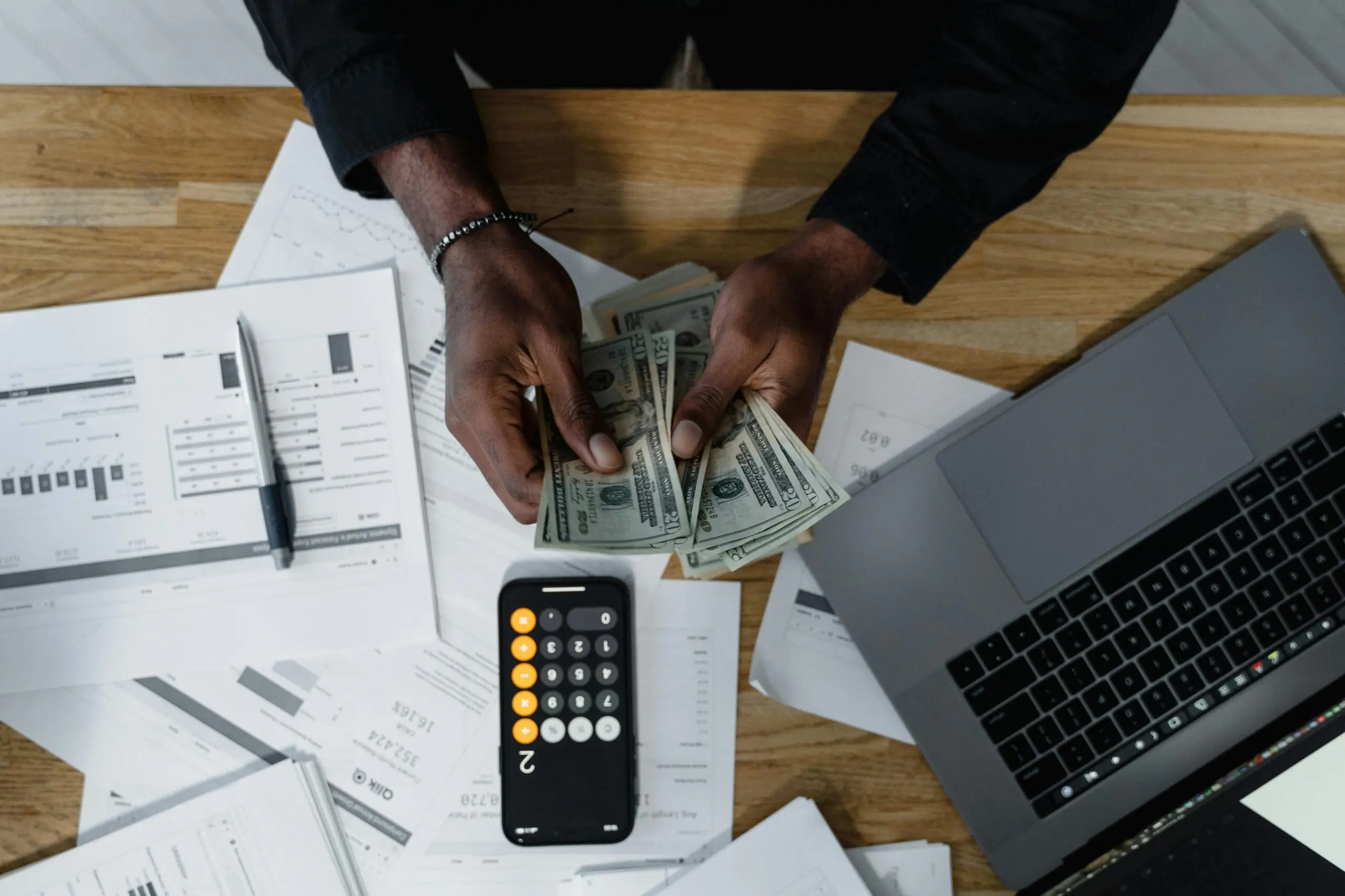 Money and office supplies on a desk.