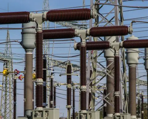 Electric transformers before a blue sky.
