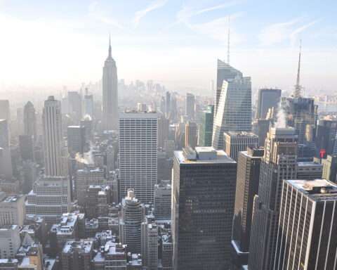 The New York City skyline form above on a sunny and hazy day.