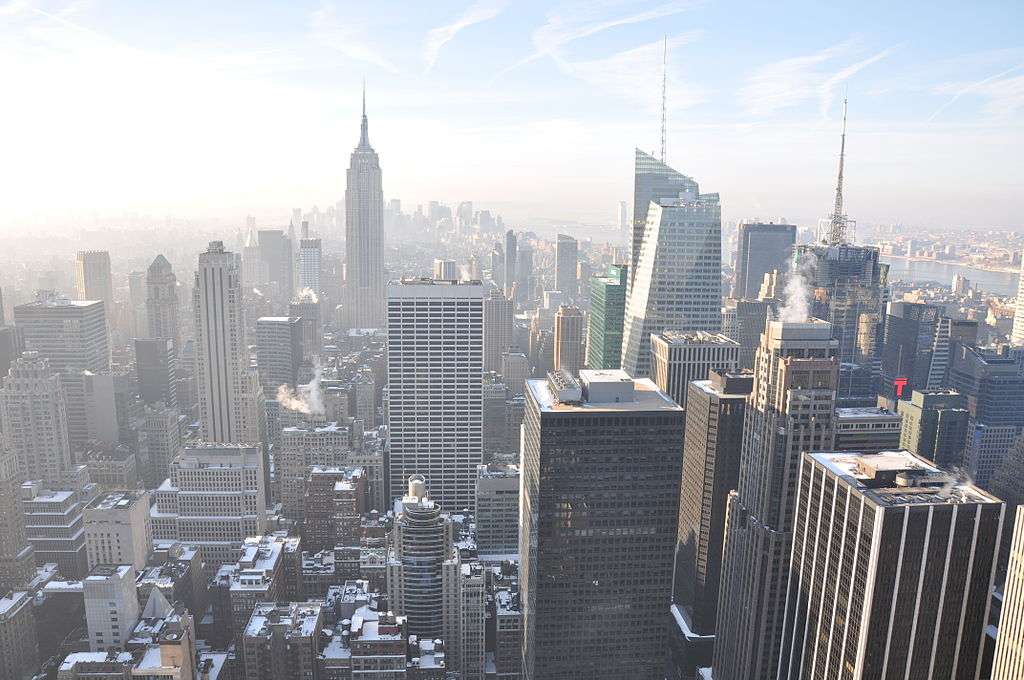 The New York City skyline form above on a sunny and hazy day.