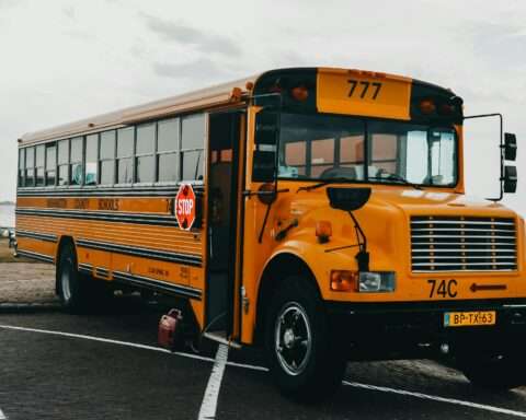 A parked school bus in a parking lot on an overcast day.