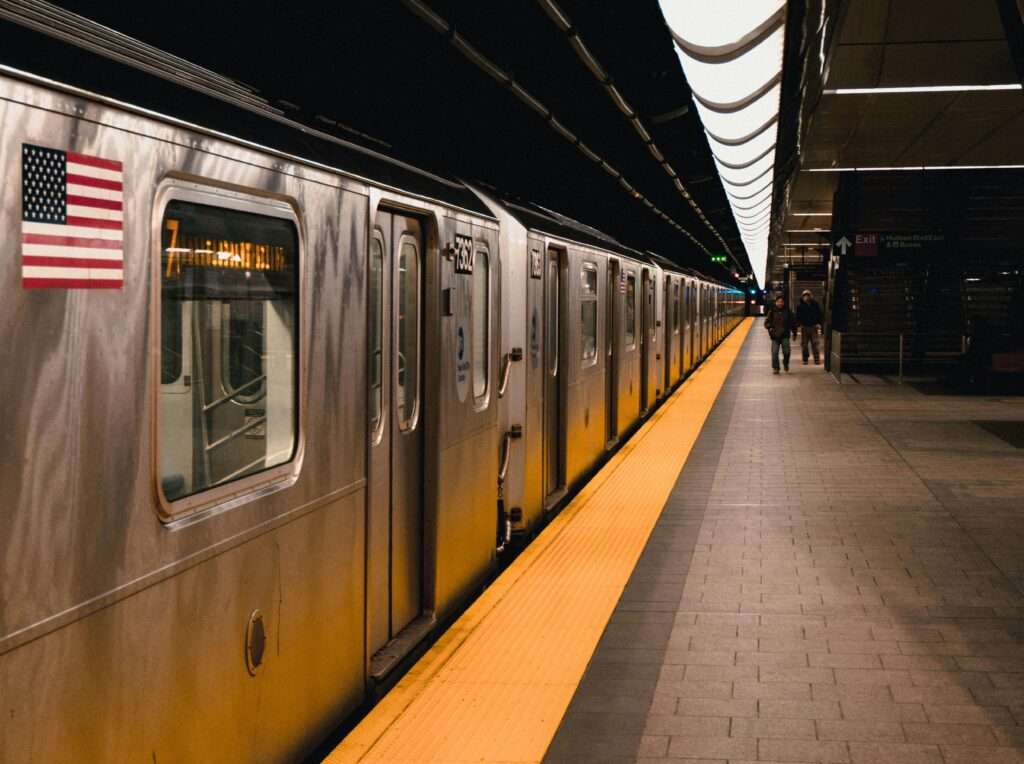 A subway station with a train and passengers in New York City.