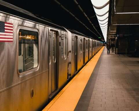 A subway station with a train and passengers in New York City.