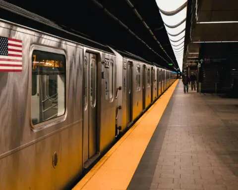 A subway station with a train and passengers in New York City.