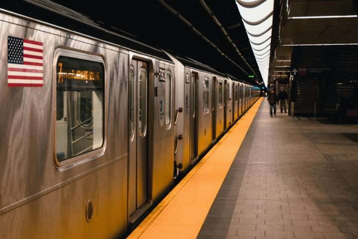 A subway station with a train and passengers in New York City.