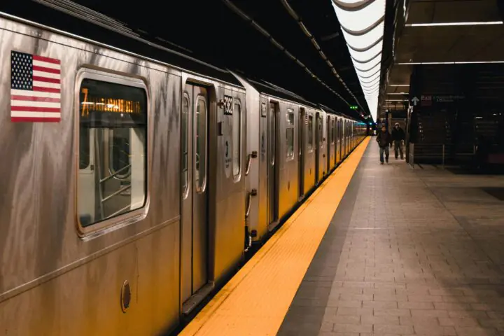 A subway station with a train and passengers in New York City.