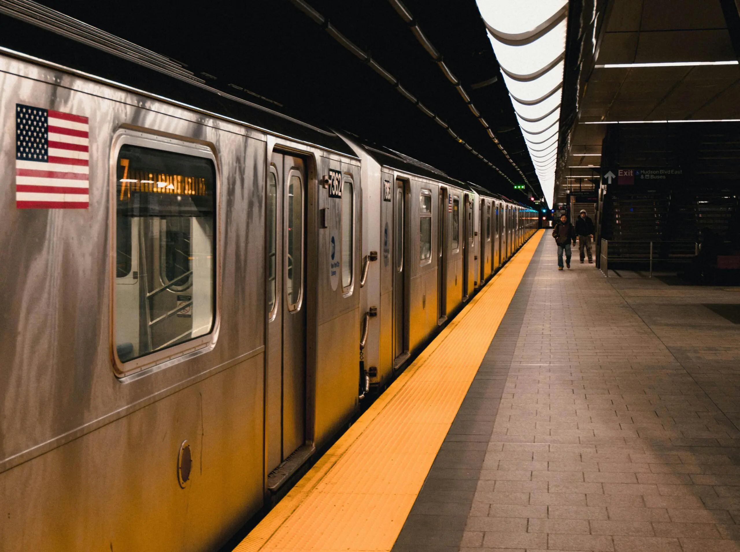 A subway station with a train and passengers in New York City.