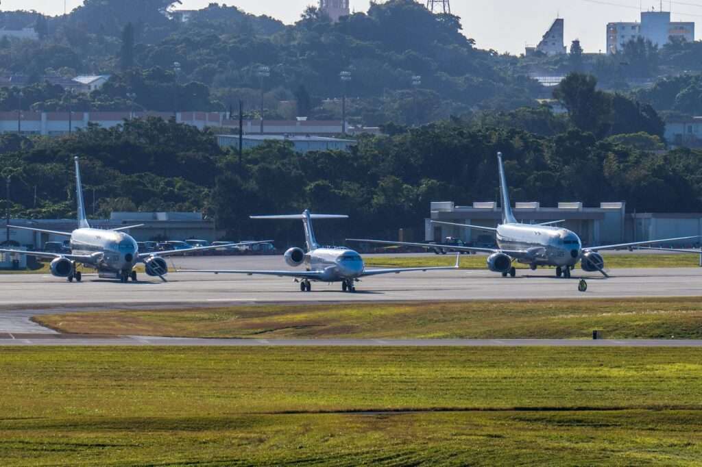 Three airplanes at a taxiway at an airport from a distance.