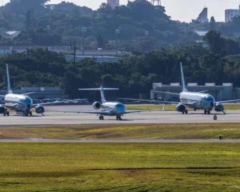 Three airplanes at a taxiway at an airport from a distance.