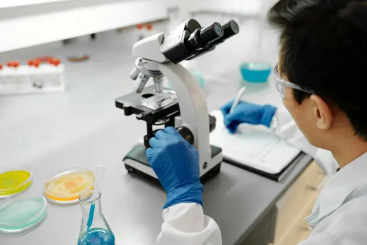 A researcher looking through a microscope at a laboratory.