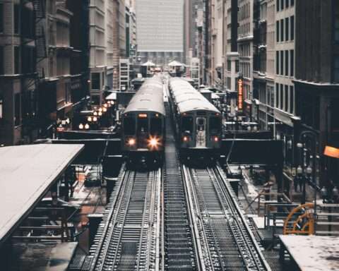 Two parallel trains on elevated tracks in Chicago.