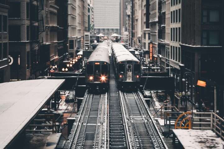 Two parallel trains on elevated tracks in Chicago.