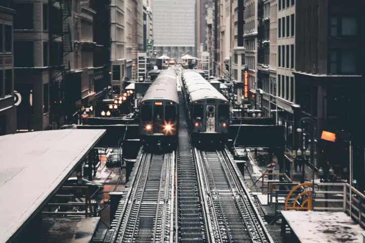Two parallel trains on elevated tracks in Chicago.
