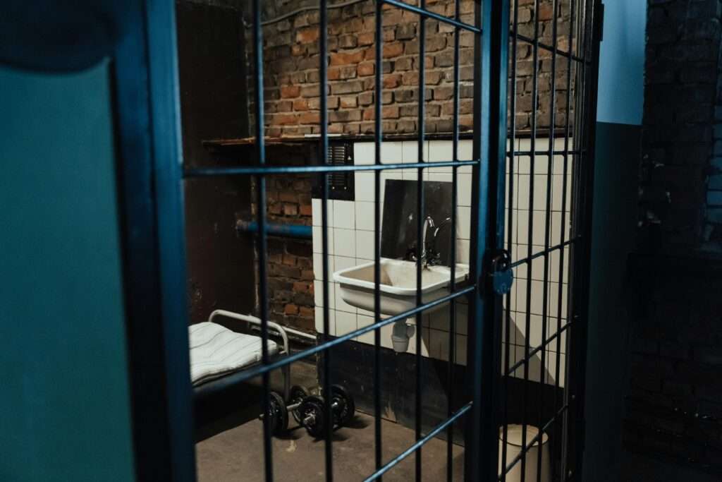 A jail room in a detention center with a sink, dumbells and a bed.