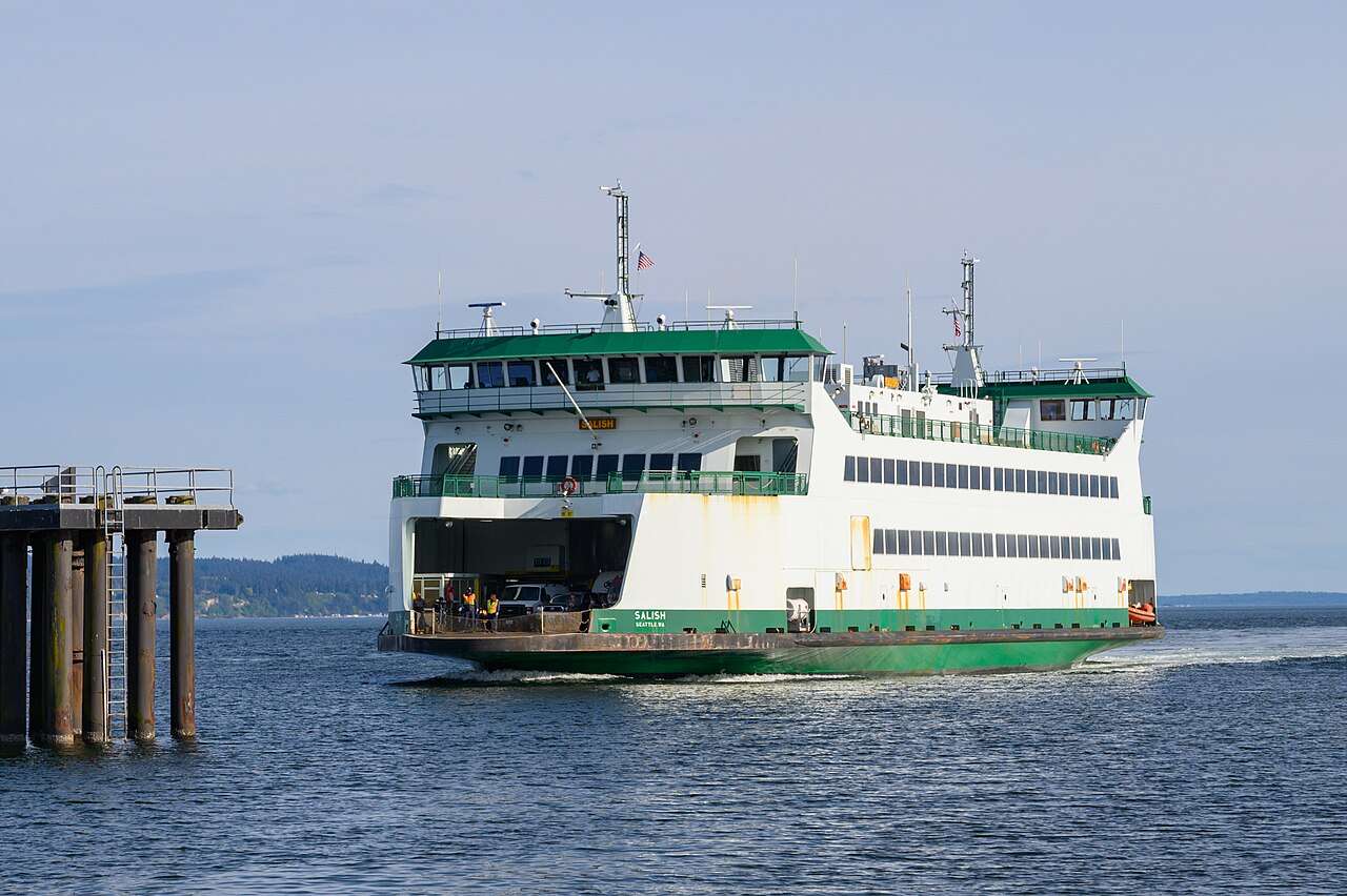 A Washington State Ferries ferry on the water before a blue horizon.