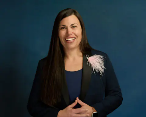 A portrait of Mayor Lacey Beaty before a blue background in Beaverton, Oregon.