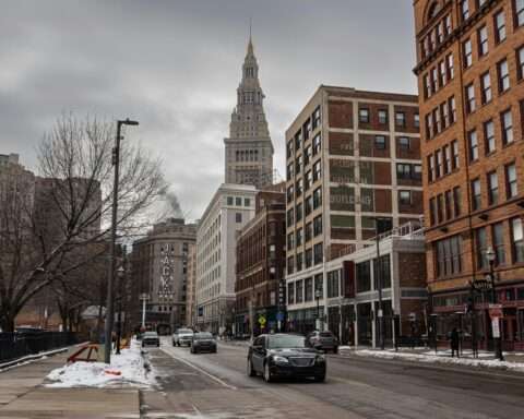A Cleveland street with cars before city buildings.