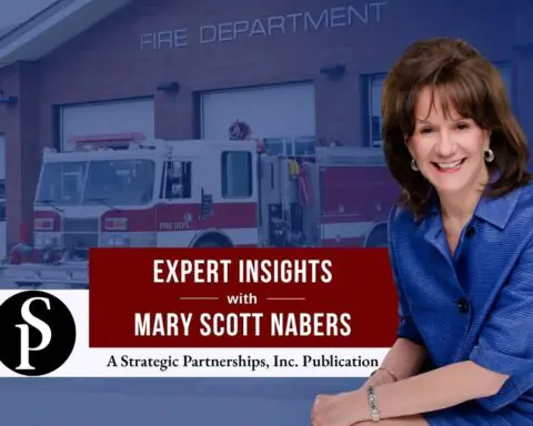 Mary Scott Nabers before a fire truck and station for her weekly column.