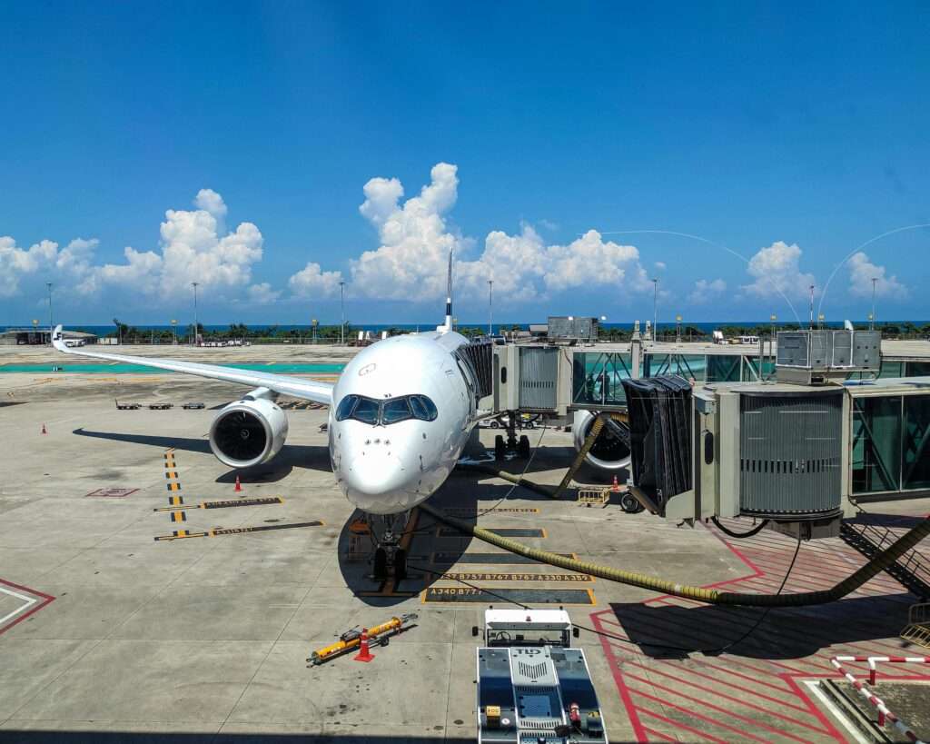 An airplane at a gate at an airport on a sunny day.