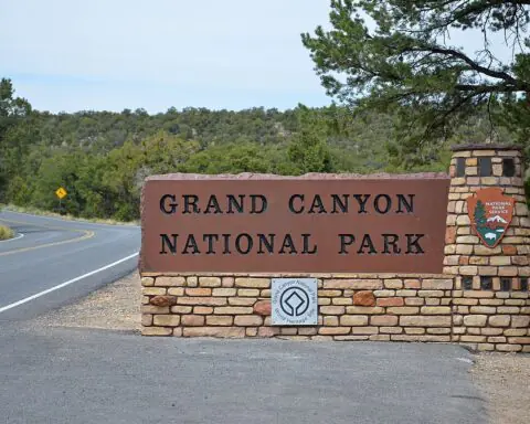 Along Highway 64, the East Entrance sign welcomes visitors to Grand Canyon National Park. Then, they are met by a set of drive-through entrance booths clad with arcing stone walls, recalling the construction of the Desert View Watchtower, in a modern interpretation that incorporates exposed steel columns and beams. NPS Photo by Michael Quinn.