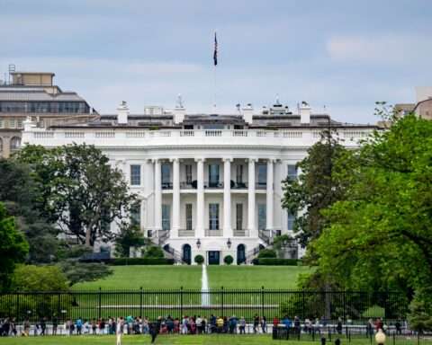 Onlookers before the White House on a sunny day.