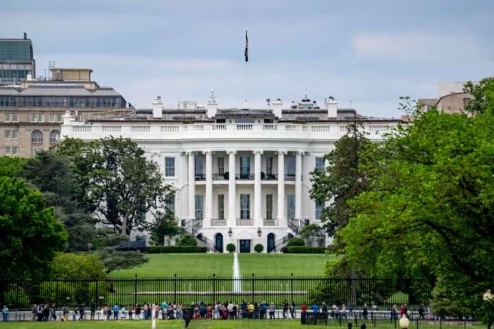 Onlookers before the White House on a sunny day.