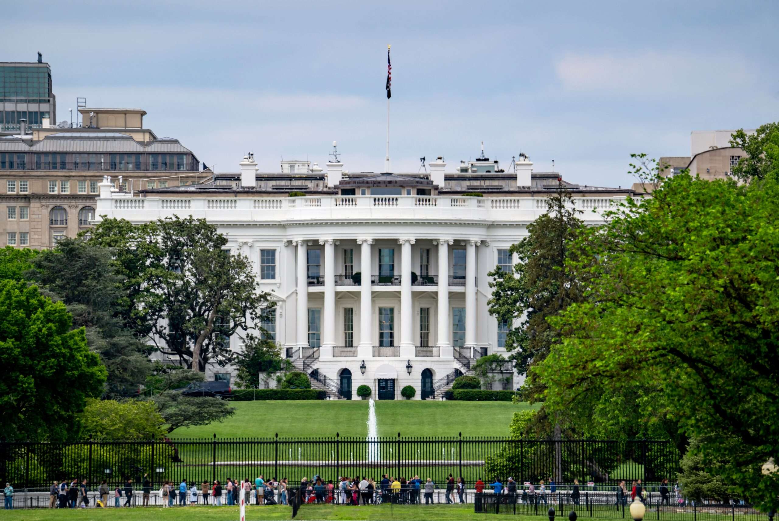 Onlookers before the White House on a sunny day.