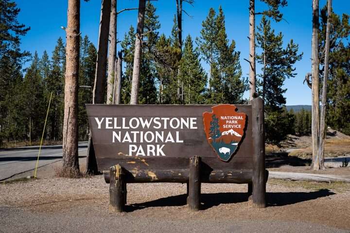 Signage for Yellowstone National Park at the south entrance, adjacent to the Bridger-Teton National Forest.