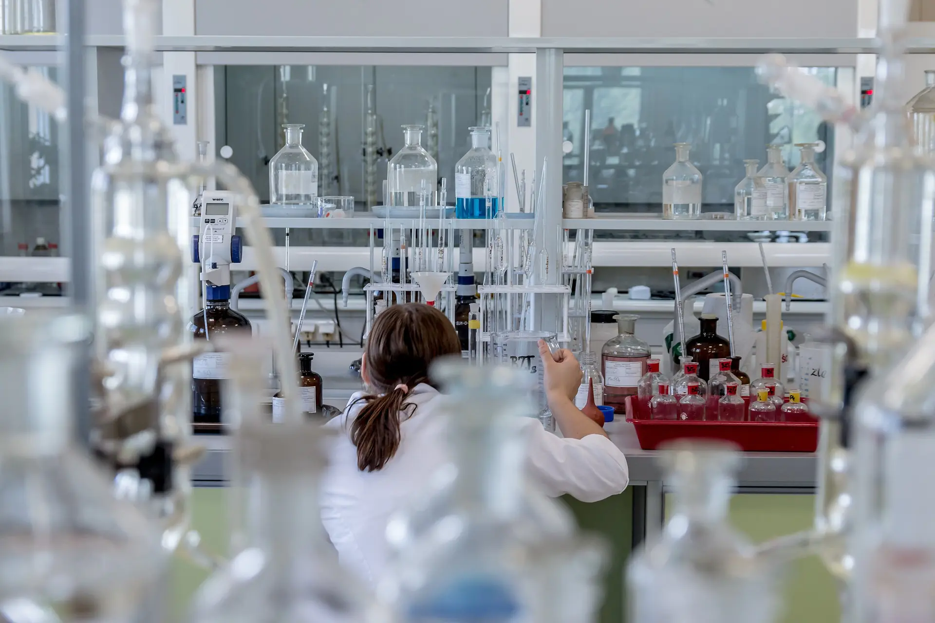 A lab researcher manages beakers and other tools in a lab.