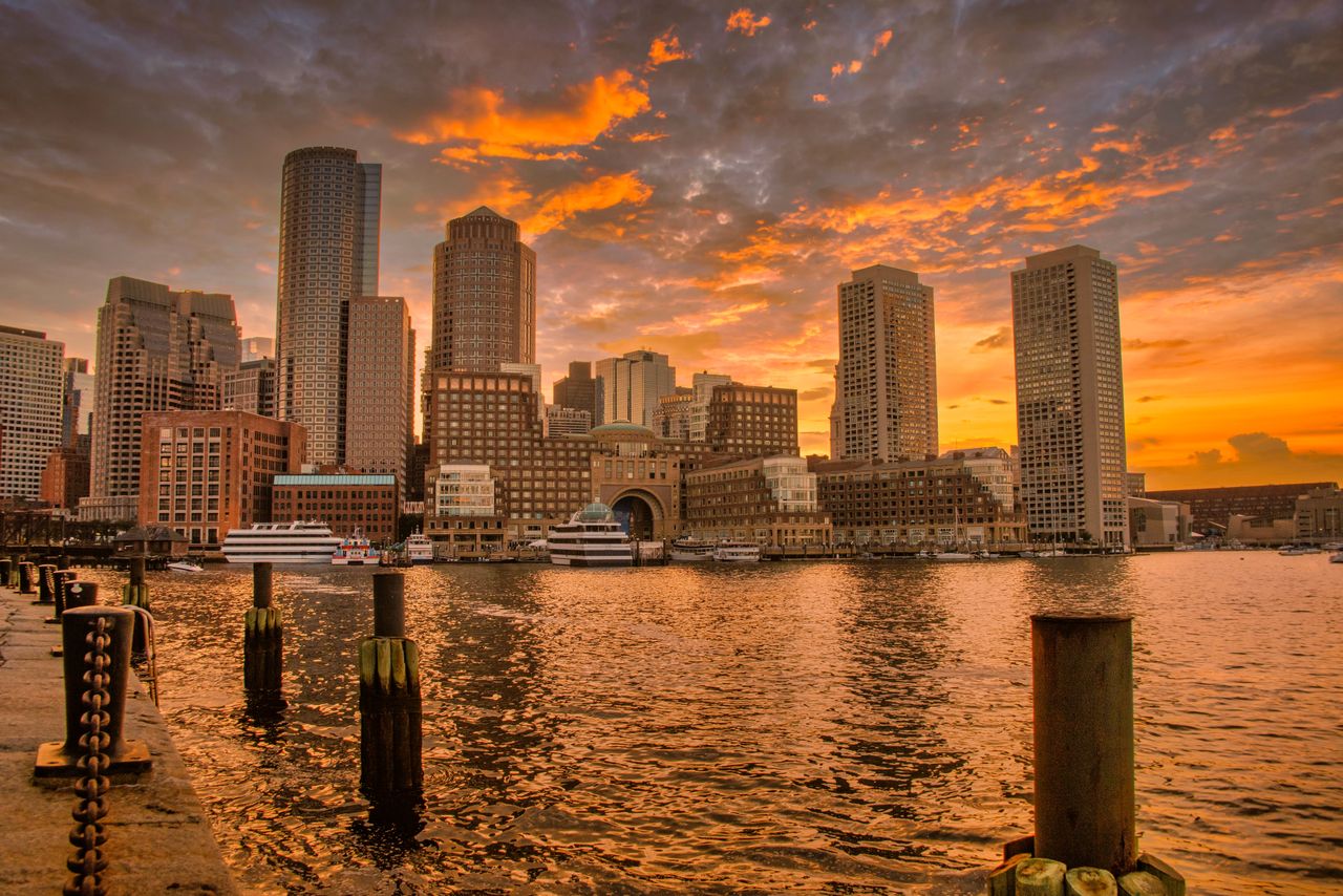 The Boston coast before a orange sunlit sky.